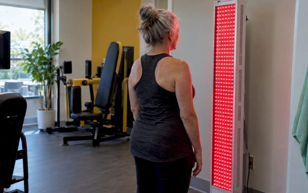 Member standing at a red light therapy panel